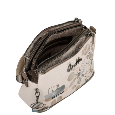 Mala feminina bege claro decorada com padrão de manchas, desenhos de anjo e textos com vários fechos de zíper.