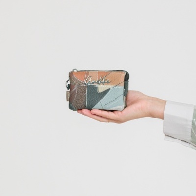 Carteira patchwork castanho bege cinza com escrita Anekke segurada por mão