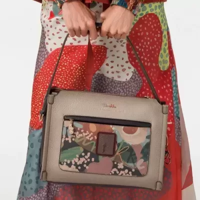 Bolsa de mão bege com bolso estampado colorido e padrão abstrato no vestido