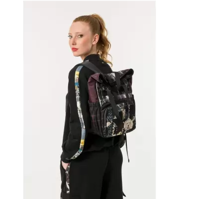 Mochila camuflada em tecido com bolso frontal e alças pretas, usada por mulher com roupa casual preta