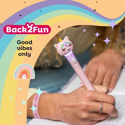 Caneta com topo de unicórnio rosa a ser usada para escrever num caderno