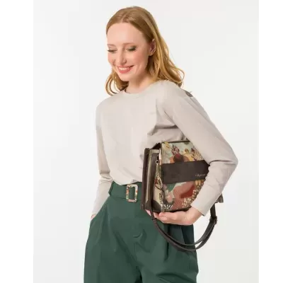 Mulher com mala de padrão floral em tons castanhos e verde