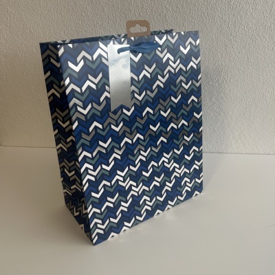Saco de papel azul com padrão de setas e faixa prateada