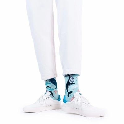 Meias azuis com padrão de baleias usadas com calças e sapatilhas brancas
