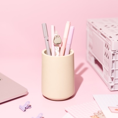 Suporte creme com canetas pastel e clip decorativo de gato