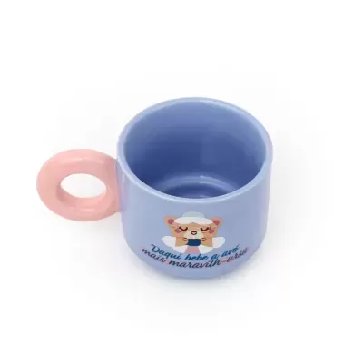 Caneca azul com pega rosa e desenho de uma ursinha com texto