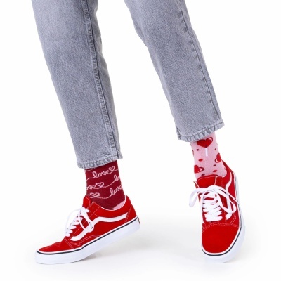 Meias coloridas com corações e texto 'love', sapatilhas vermelhas, jeans azul