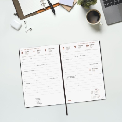 Agenda semanal aberta em branco sobre mesa com acessórios de escritório