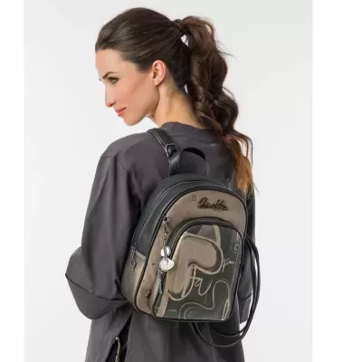 Mochila pequena castanha e preta com design abstrato, pendente em forma de nota musical, usada por mulher de perfil