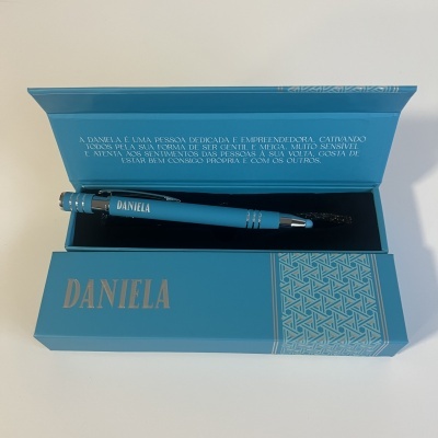 Estojo azul com caneta azul e texto em português dentro do estojo.