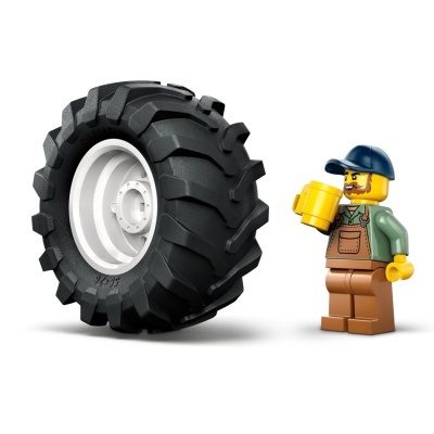Figura Lego com boné e macacão segurando caneca ao lado de uma roda negra grande