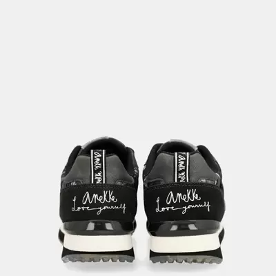 Sapatilhas pretas com frase bordada Anekke love yourself na parte de trás.