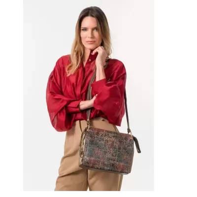 Mulher com blusa vermelha e mala tiracolo quadriculada multicolorida