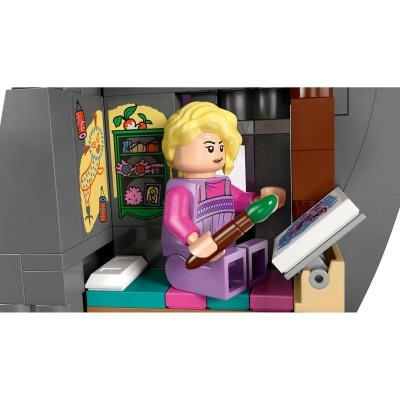 Minifigura LEGO de mulher loira com pincel e livro, sentada num banco colorido