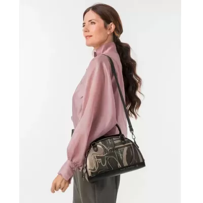 Mala de mão padrão castanho e preto com palavras, usada por mulher com camisa rosa