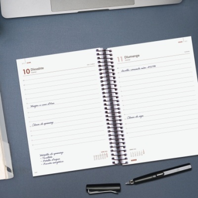 Agenda semanal aberta ao dia 10 e 11 de dezembro com caneta preta em cima de superfície azul