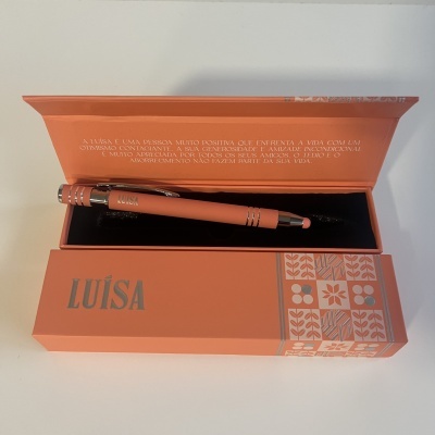 Conjunto de caneta e caixa laranja com padrões florais e texto LUÍSA
