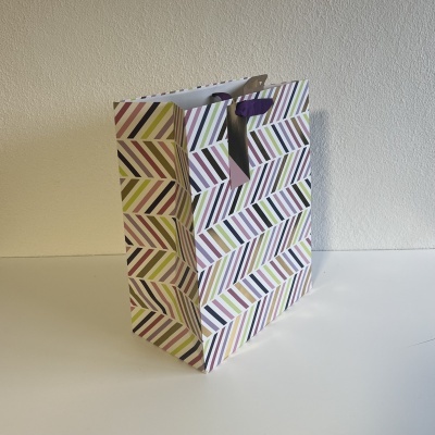 Saco de papel colorido com riscas diagonais e alças roxas