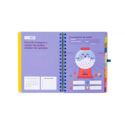 Planner mensal aberto com página de setembro em lilás e ilustração de máquina de bolas