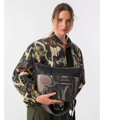 Mulher com casaco estampado a segurar mala preta Anekke