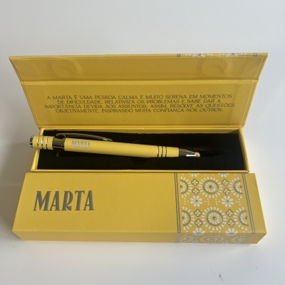 Conjunto de caneta amarela em estojo amarelo com o nome Marta, texto em português interno, fundo branco
