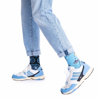 Meias coloridas com padrão de bicicletas usadas com jeans azul claro e ténis brancos e azuis.