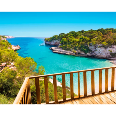 Varanda de madeira com vista para baía e praia com água azul e vegetação