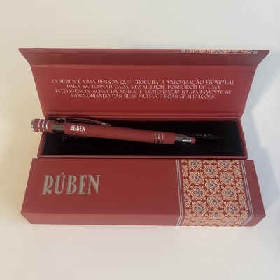 Conjunto de caneta vermelha com estojo vermelho e texto em português na tampa interior.