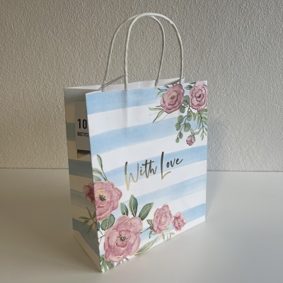 Saco de presente com padrão azul e branco e flores cor-de-rosa