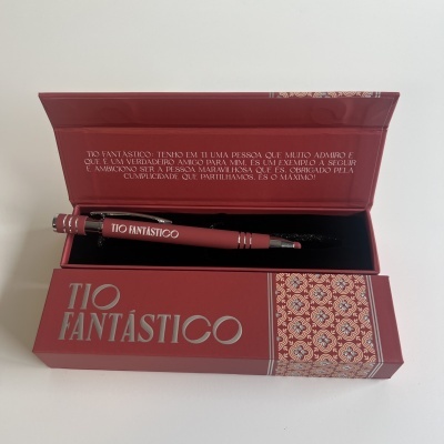Caneta preta e vinho TIO FANTÁSTICO em caixa vinho com padrão decorativo