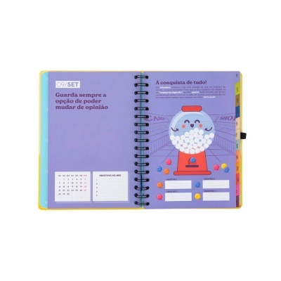 Caderno aberto com calendário, texto em português e ilustração de máquina de bolas de gomas