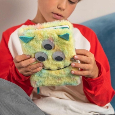 Capa felpuda multicolor com olhos móveis azul e verde em mãos de criança.