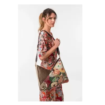 Mulher com vestido floral colorido e mala tiracolo estampada e castanha.