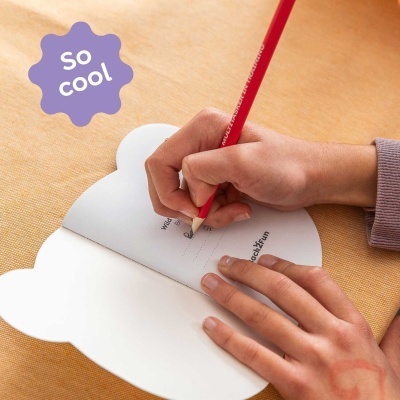 Livro em forma de nuvem com mãos escrevendo, lápis vermelho e selo roxo com texto
