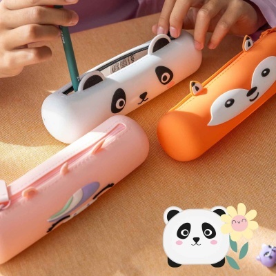 Três estojos de silicone com design de animais em cores branco, laranja e rosa sobre uma mesa bege