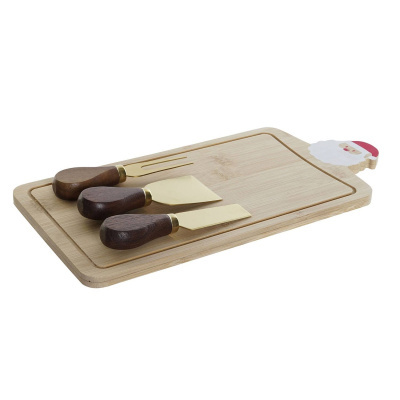 Tábua de corte de madeira clara com figura de Pai Natal e três utensílios para queijo com cabos de madeira escura e lâminas douradas