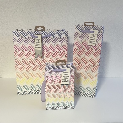 Três embalagens de papel com padrão ondulado colorido e etiquetas com instruções