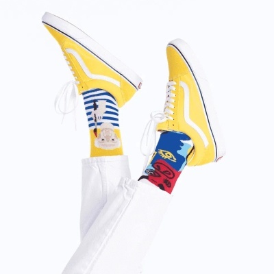 Sapatilhas amarelas com risca branca e meias coloridas com padrão gráfico