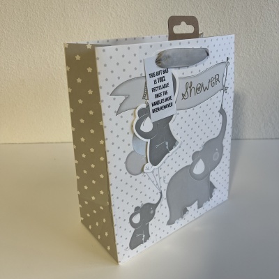 Saco de presente cinzento com padrão de estrelas e bolinhas, desenhos de elefantes e balões