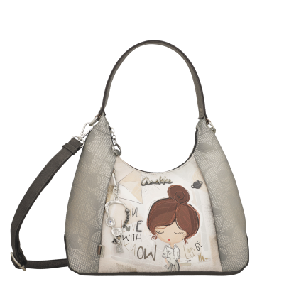 Mala de ombro cinza e bege com ilustração de menina e texto parcial, pendente e etiqueta Anekke