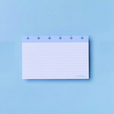 Bloco de notas branco pautado com margem azul sobre fundo azul claro