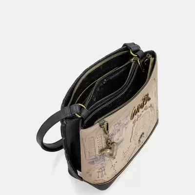 Mala de ombro preta e bege com padrão ilustrativo e detalhes metálicos dourados