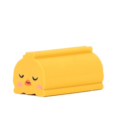 Espuma amarela em forma de pintainho deitado com olhos fechados.