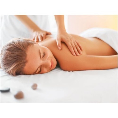 Pessoa a receber massagem nas costas numa cama de massagem com toalha branca