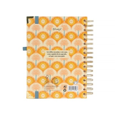 agenda com capa decorada com sóis amarelos e laranjas e árvores estilizadas, espiral dourada e elástico azul