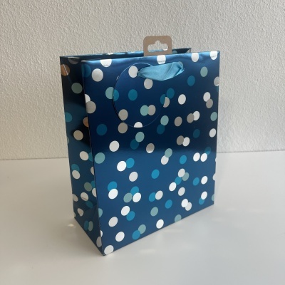 Saco de presente azul escuro com padrão de pontos coloridos e alça recortada