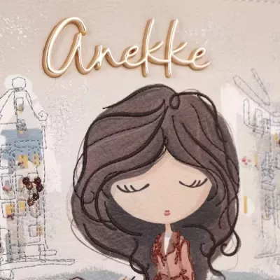 Acessório creme com desenho e texto Anekke em relevo dourado