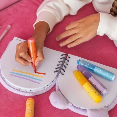 Marcadores coloridos e caderno aberto a ser usado