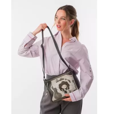 Mulher com camisa rosa e mala tiracolo Anekke bege e castanha