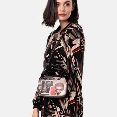 Mulher com vestido estampado e bolsa pequena com estampa artística